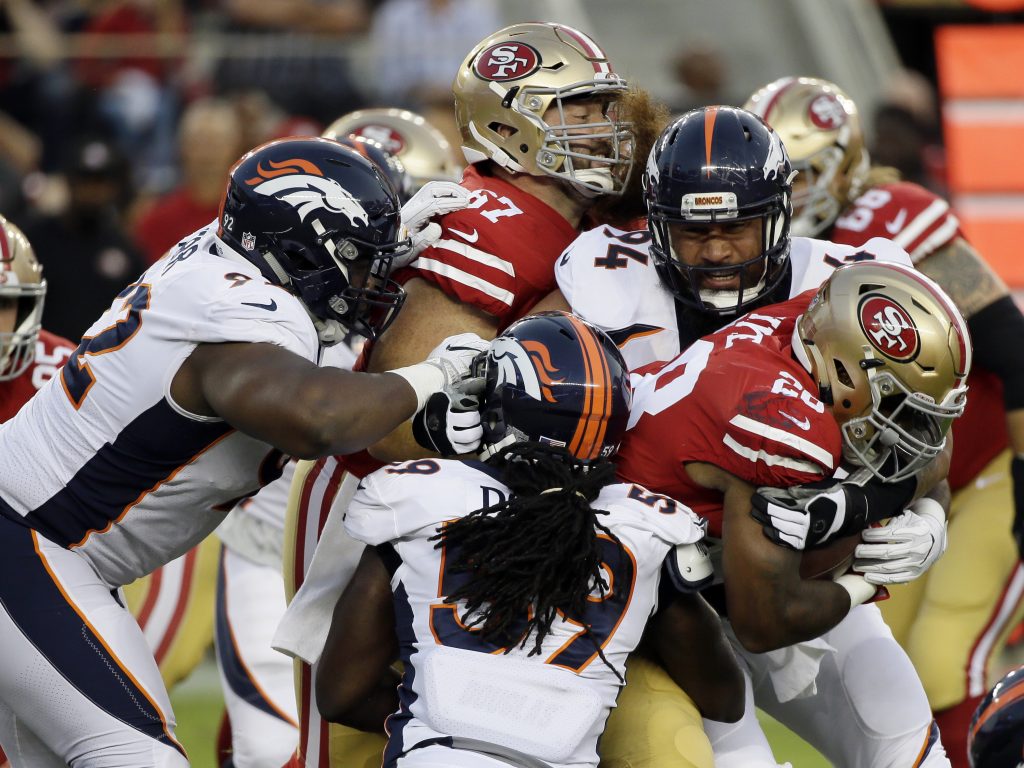 Running back Carlos Hyde gets tackled during the 49ers preseason game against the Broncos